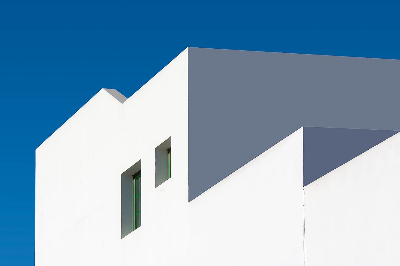 White cubic facade against blue sky